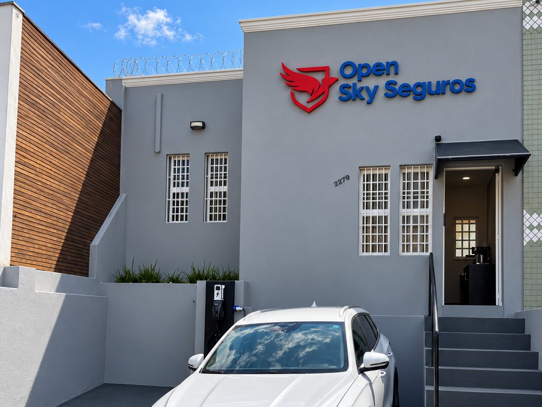 Fachada da Open Sky Seguros com o logo, a entrada e o carro no estacionamento