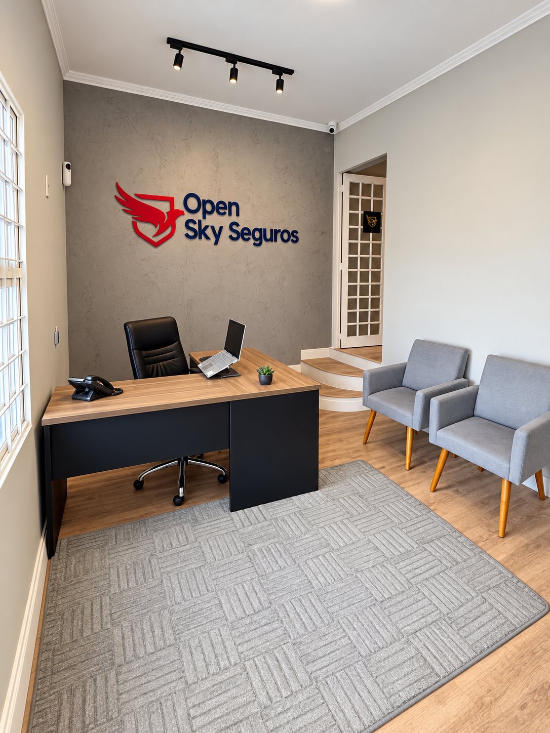 Recepção da Open Sky com o logo na parede, mesa de atendimento e poltronas